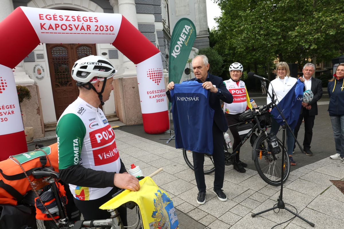 Szita Károly polgármester átadja a KAPOSVÁR feliratú mellényt Bajna Balázsnak és Szepesi Andrásnak a kerékpártúra rajtja előtt